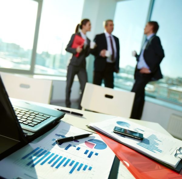 Equipe reunida em escritório analisando relatórios de gestão